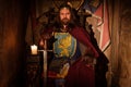 Medieval king on throne in ancient castle interior.