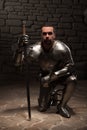 Medieval knight kneeling with sword Royalty Free Stock Photo