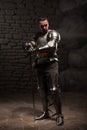 Medieval Knight posing with sword in a dark stone Royalty Free Stock Photo