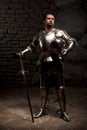 Medieval Knight posing with sword in a dark stone Royalty Free Stock Photo