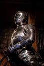 Medieval like shiny armour suit and helmet in position of riding a horse