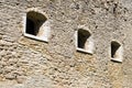 Medieval limestone wall with three windows