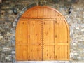 Medieval looking arched top doors set in a stone castle wall