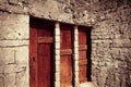 medieval mahogany door with crossbars in stone wall.