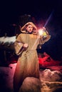 Medieval monk in canvas sackcloth robe with lattern in dark forest with snow and red light on winter night. Fantasy or fairy tale Royalty Free Stock Photo