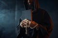 Medieval monk holds book and wooden cross in hands Royalty Free Stock Photo