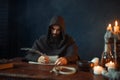 Medieval monk sitting at table and write, top view