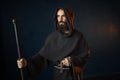 Medieval monk with wooden stick and cross in hands Royalty Free Stock Photo