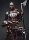 Brave african soldier from the past looking at camera holding an axe