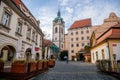 Medieval narrow old city street with numerous cafes, castle and high clock tower of the Church of Saints Peter and Paul in Melnik Royalty Free Stock Photo