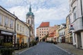 Medieval narrow old city street with numerous cafes, castle and high clock tower of the Church of Saints Peter and Paul in Melnik Royalty Free Stock Photo