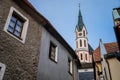 Medieval narrow street with colorful renaissance historical buildings, tower of the St. Vitus Church in the center of Cesky