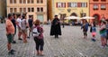 The Medieval Night Watchman of Rothenburg walks on the cobblestones on Rothenburg while tourists watch