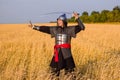 A medieval nomad warrior in oriental armor on the background of a wheat field. Standing in a fencing rack Royalty Free Stock Photo