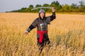 A medieval nomad warrior in oriental armor on the background of a wheat field. Standing in a fencing rack Royalty Free Stock Photo