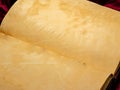 medieval old book open on a table with red velvet, aged yellowed pages empty without text. Royalty Free Stock Photo