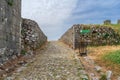 Medieval paved road among ruins of Rozafa Castle with a restaurant sign