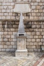 A medieval pillory stands in front of the 17th Century Clock Tower