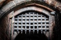 Medieval portcullis gate seen in the opened position at the entrance to a historic building