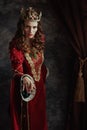 medieval queen in red dress with crown making reverence Royalty Free Stock Photo