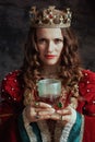 medieval queen in red dress with goblet and crown Royalty Free Stock Photo