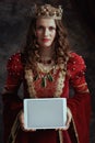medieval queen in red dress showing tablet PC blank screen