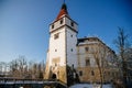 Medieval renaissance water castle with half-timbered tower with snow in winter sunny day, Historic Romantic chateau Blatna near