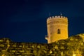 Medieval ruin of a watch tower at night with stone wall in the foreground Royalty Free Stock Photo