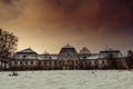 Medieval snowy castle in winter at night with beautiful orange - red sky. Creepy castle in Slovakia. European historic large castl