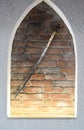 Medieval steel sword against the brick wall background. Ancient shining sword used as decoration