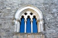 Medieval stone wall with ornate arched window and columns in ancient castle architecture Italy Royalty Free Stock Photo