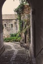 Medieval street arch in provence. Ancient european architecture. Charming brick castle gate with flowers and plants and lantern. Royalty Free Stock Photo