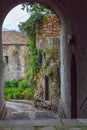 Medieval street arch in provence. Ancient european architecture. Charming brick castle gate with flowers and plants and lantern. Royalty Free Stock Photo