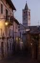 A medieval street in Assisi with view on the tower of Basilica of Saint Clare, by night. Italy Royalty Free Stock Photo