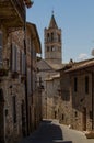 A medieval street in Assisi with view on the tower of Basilica of Saint Clare, by day. Italy Royalty Free Stock Photo
