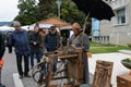 A medieval street craftsman produces and sells his products