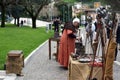 A medieval street craftsman produces and sells his products