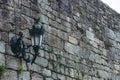 Medieval street lamp on old brick wall colored. Facade of ancient buiding, Europe. Grunge outdoor design. Old castle wall. Royalty Free Stock Photo