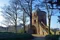 Medieval tower in sunlight surrounded by trees.