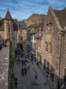 Medieval village lane and buildings on Mont St Michel with tourists waking down the lane.