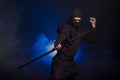 Medieval warrior assassin ninja with sword in aggressive pose in smoke Royalty Free Stock Photo