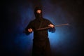 Medieval warrior assassin ninja with sword in aggressive pose in smoke Royalty Free Stock Photo