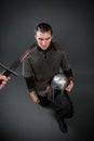 A medieval warrior in chain mail sits on his knee with a helmet in his hands. Knighting Royalty Free Stock Photo