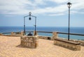 Medieval water well and bench scene over sea background Royalty Free Stock Photo