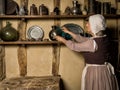 Medieval woman cleaning in castle kitchen Royalty Free Stock Photo