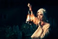 Medieval Woman with the Finger on the Lips Holding a Lamp Royalty Free Stock Photo