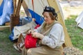 Captivating Medieval Crafts: A Woman Sewing a Red Hat at the Knight Festival