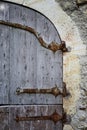 Medieval wooden door on a old wall background with hardware elem Royalty Free Stock Photo