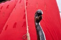 Medieval wooden figure on the bow of a ship, a sailboat with a red sail. Reconstruction of the events of the Middle Ages in Europe Royalty Free Stock Photo