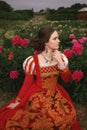 Medieval young princess in peony garden